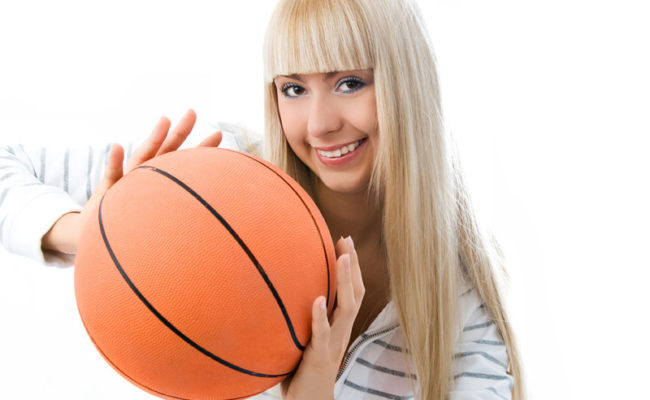 cheerful girl throwing a basketball ball